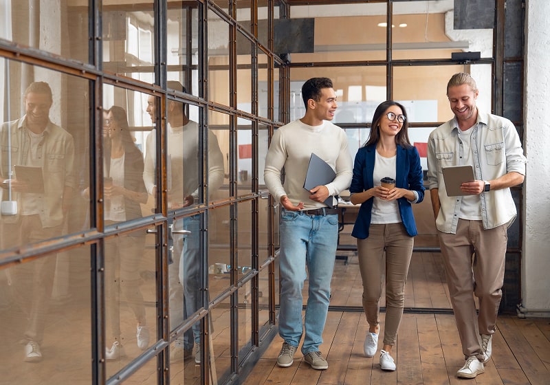 KT - Three people walking in office