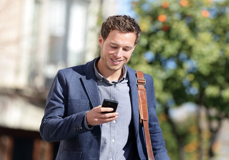 KT - A businessmen looking at phone